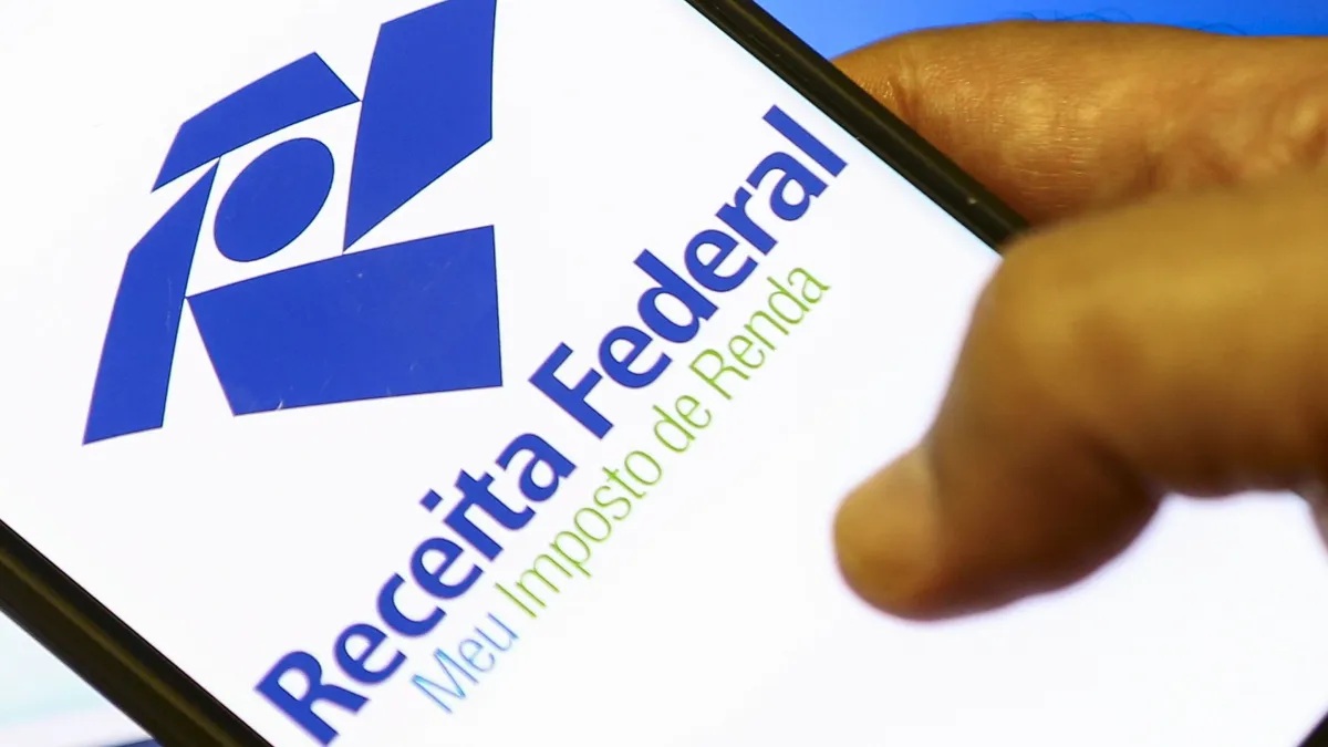 Contribuintes acessando site da Receita Federal para consultar restituição.